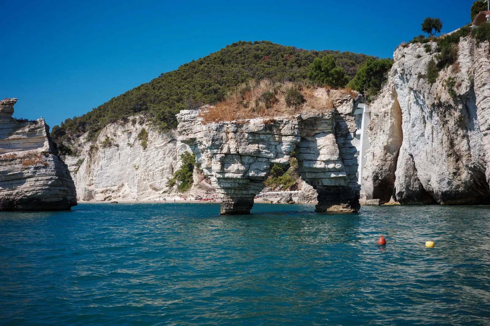 Le falesie calcaree e i faraglioni della Baia delle Zagare sul Gargano visti dal mare