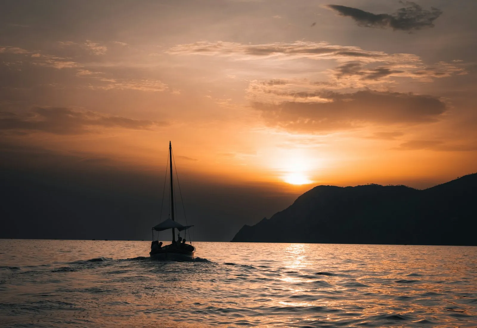 Barca a vela silhouette al tramonto in navigazione al largo