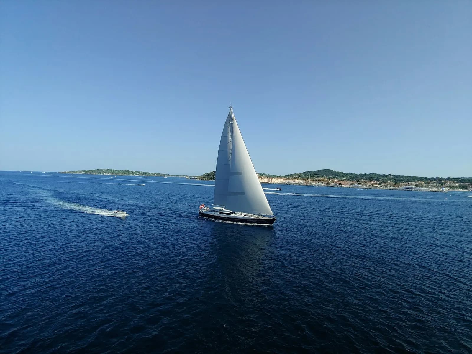 Una barca a vela in navigazione al largo con le vele spiegate nel mare del Mediterraneo