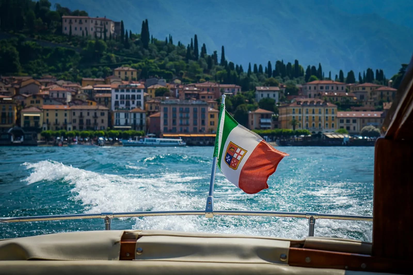 Vista di Bellagio dal pozzetto di una barca con la bandiera italiana, Lago di Como