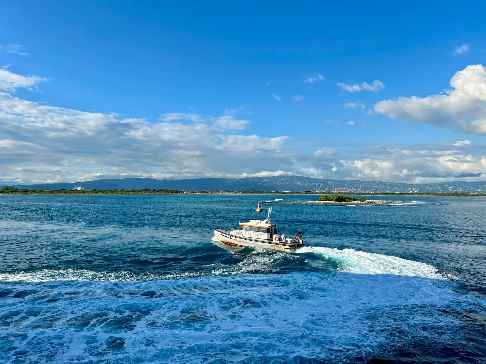 Piccola barca cabinata bianca naviga su un mare blu
