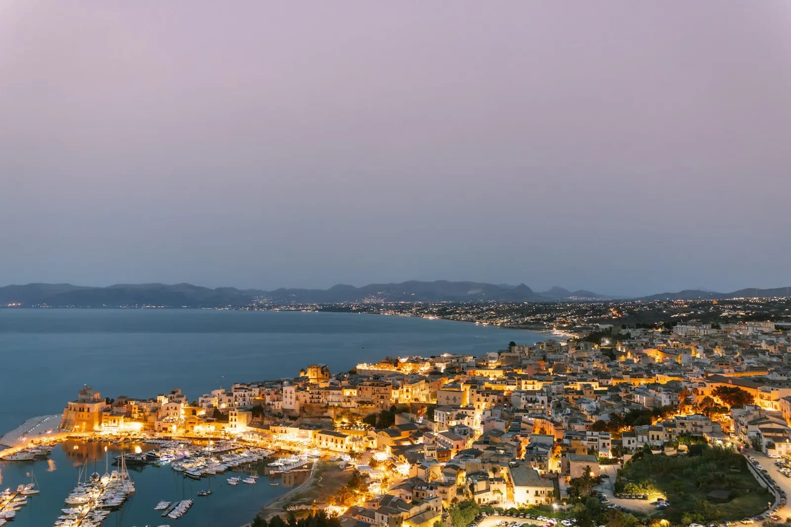 Il porto di Castellammare del Golfo al tramonto con le barche e le montagne sullo sfondo