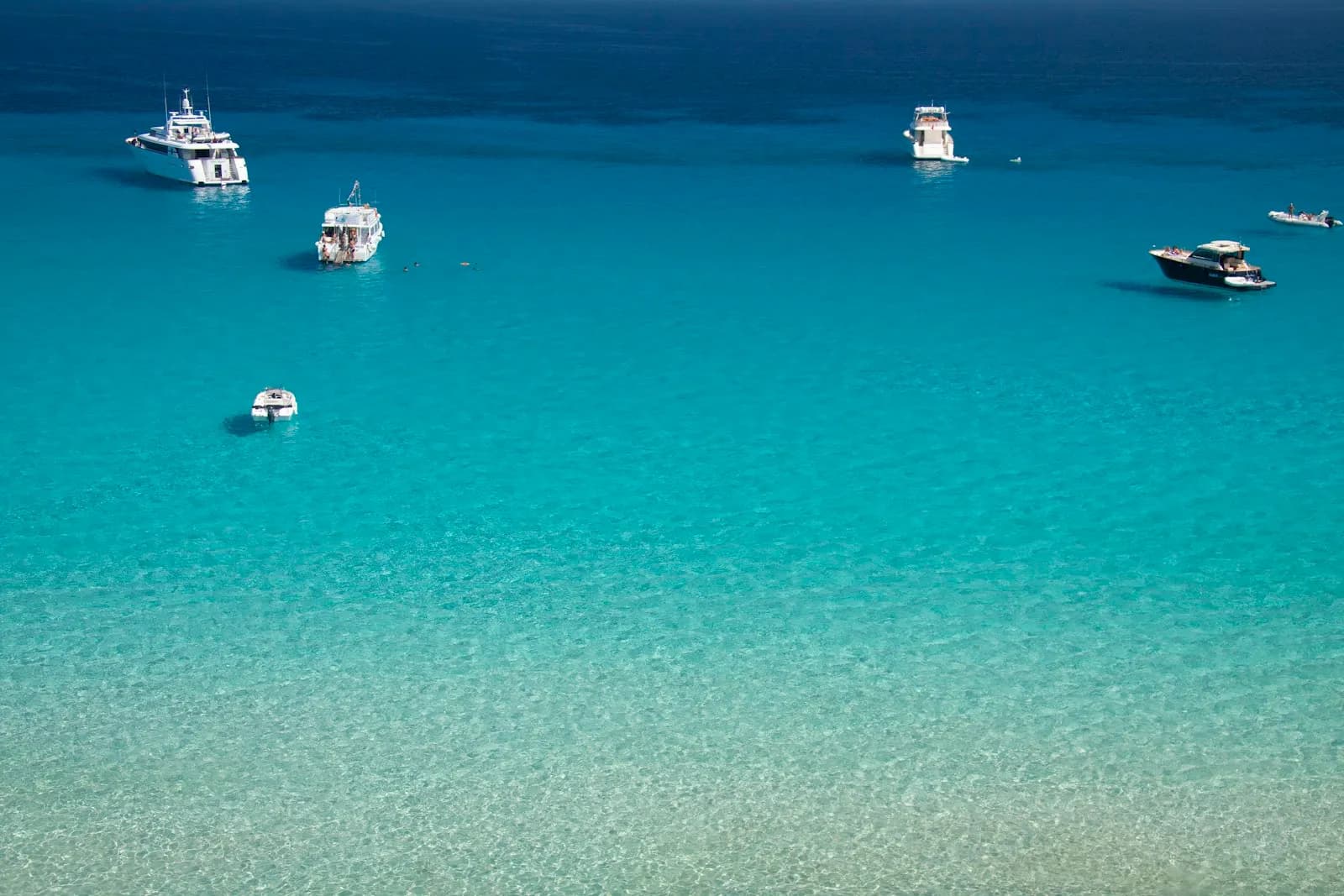 Barche all'ancora nelle acque turchesi di Cala Rossa, Favignana, isole Egadi