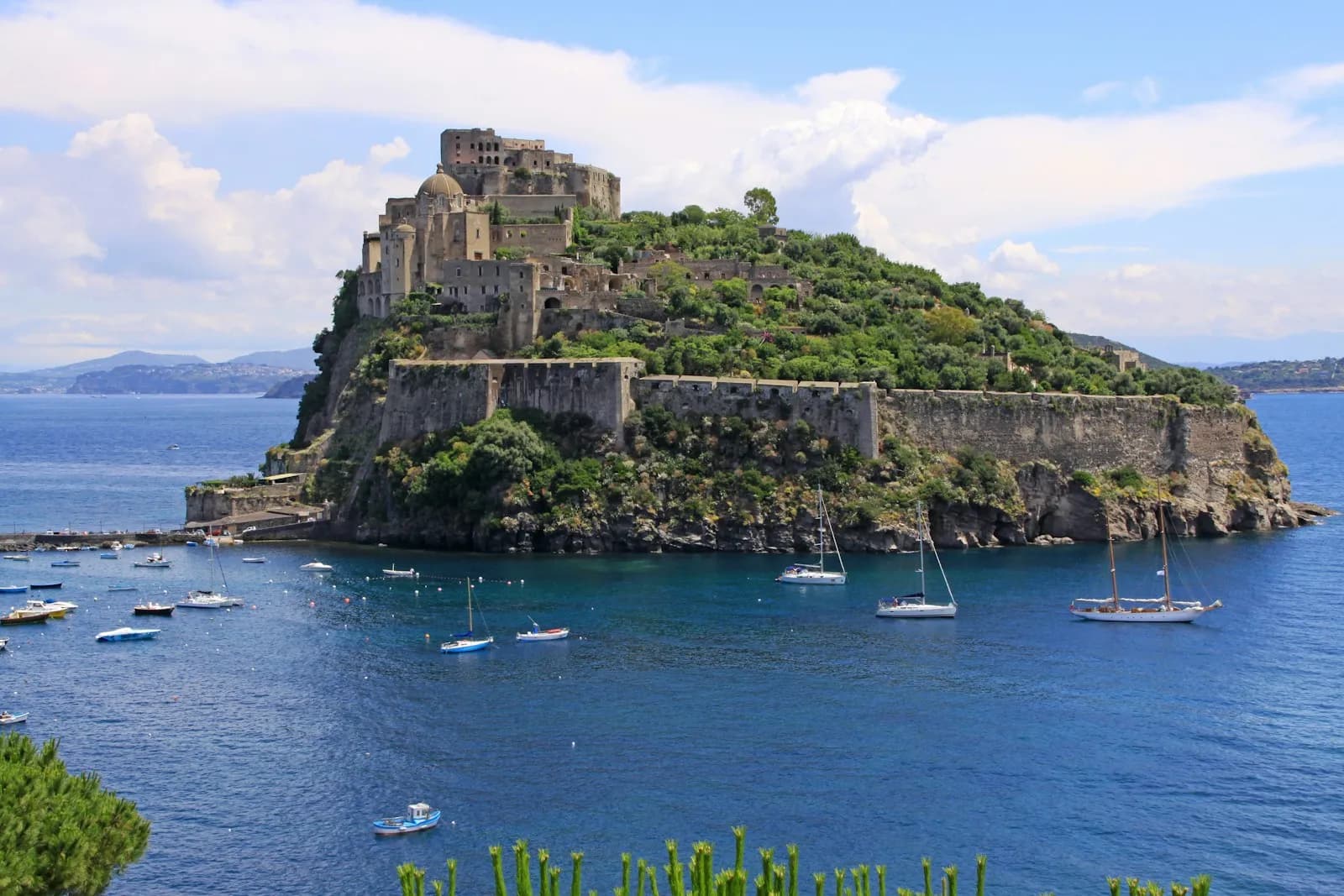 Il Castello Aragonese di Ischia con alcune barche nel mare azzurro