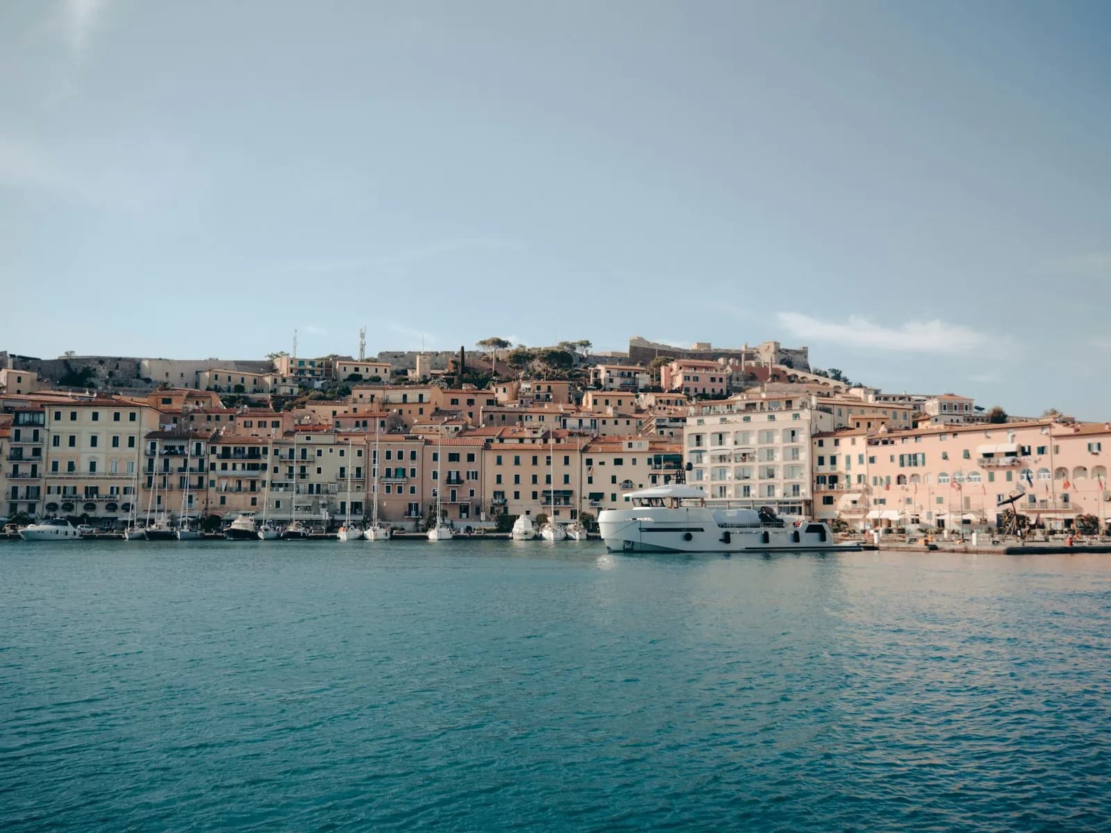 Veduta del porto di Portoferraio all'Isola d'Elba con barche ormeggiate e case colorate sul lungomare