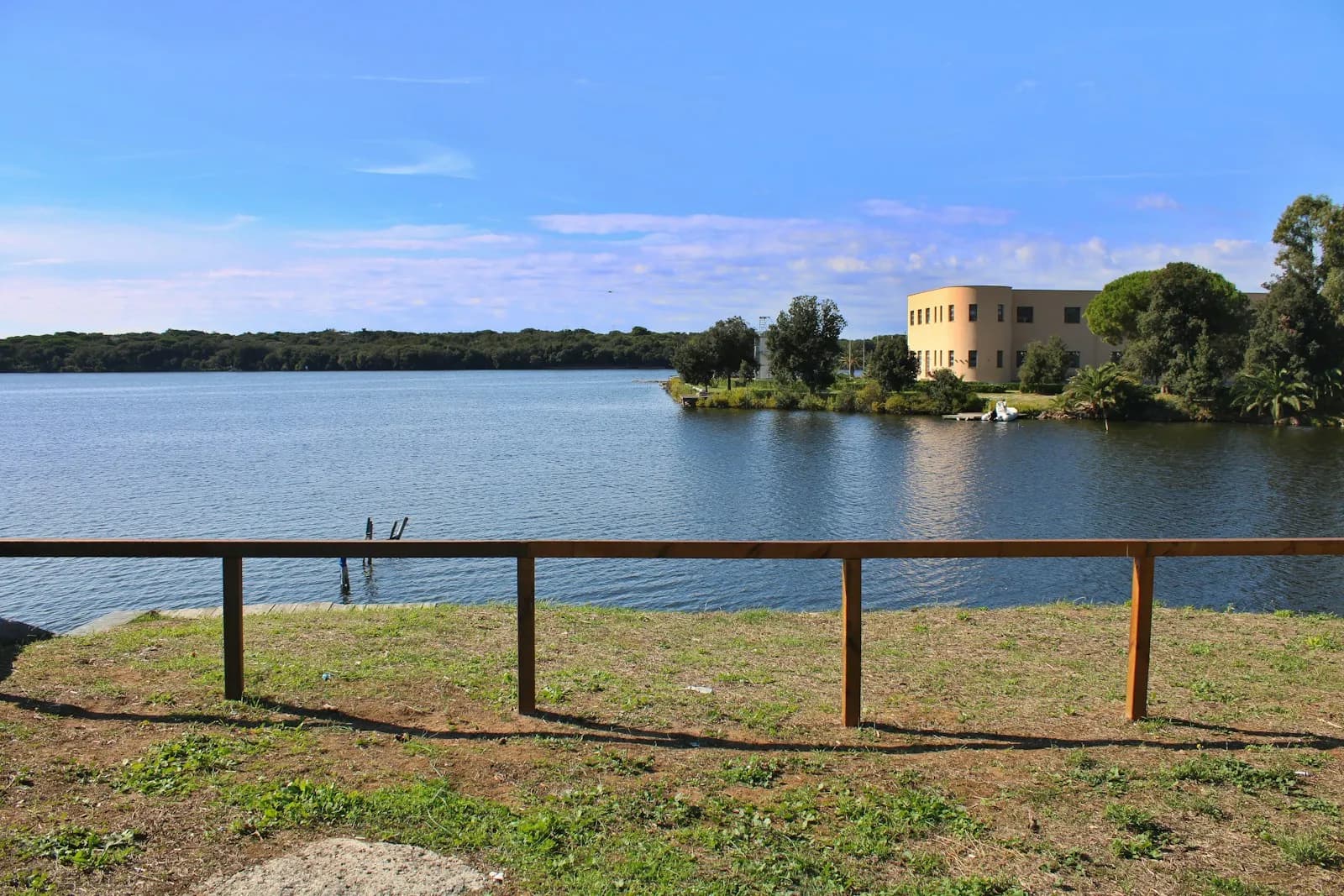 Il Lago di Paola a Sabaudia, acque calme con un edificio storico sulla riva opposta