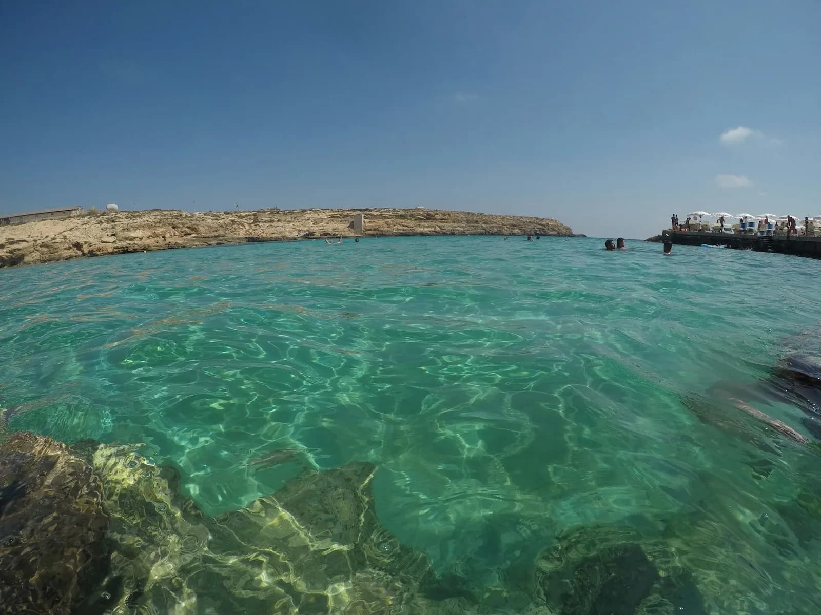 Le acque turchesi e basse di Lampedusa tra le rocce