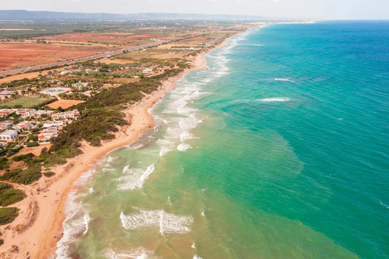 Spiaggia sabbiosa e acqua turchese bassa del litorale pugliese