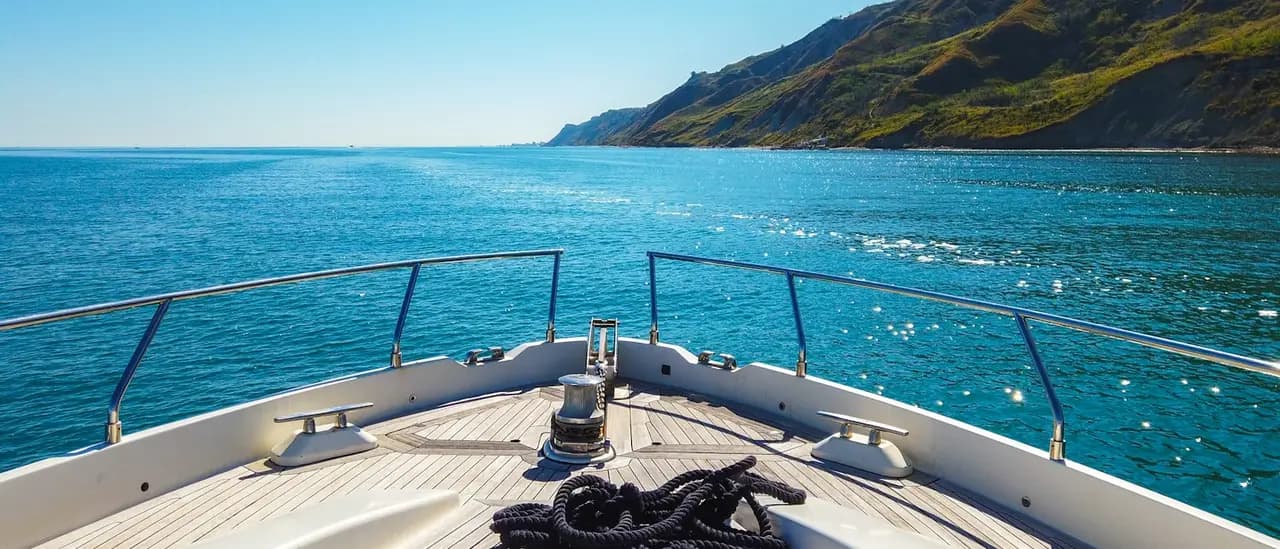 Yacht di lusso con equipaggio ormeggiato in una baia del Mediterraneo
