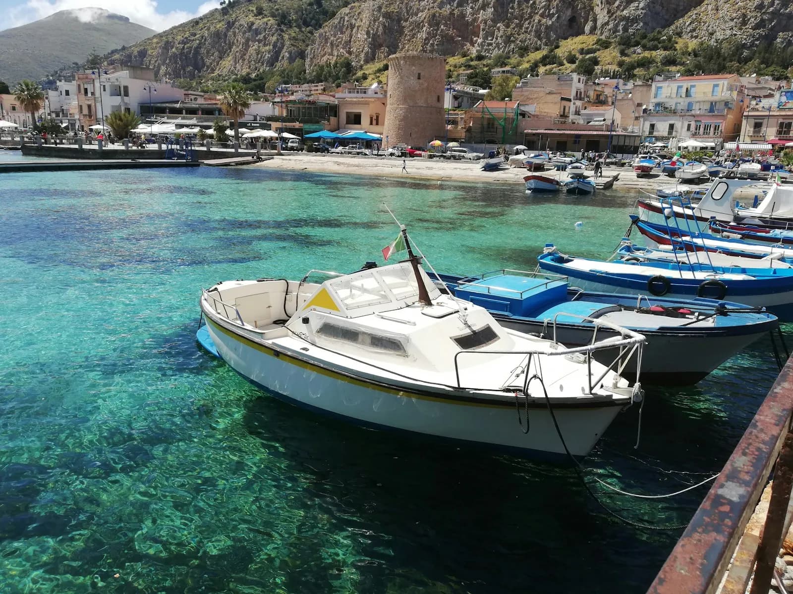 Barche ormeggiate in acque turchesi lungo la costa di Palermo, Sicilia