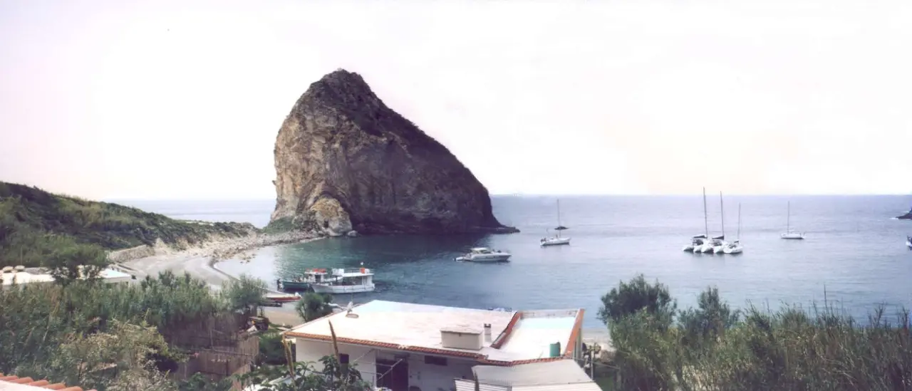 Cala del Porto a Palmarola, con il grande scoglio, il ristorante O'Francese e barche ormeggiate nella baia