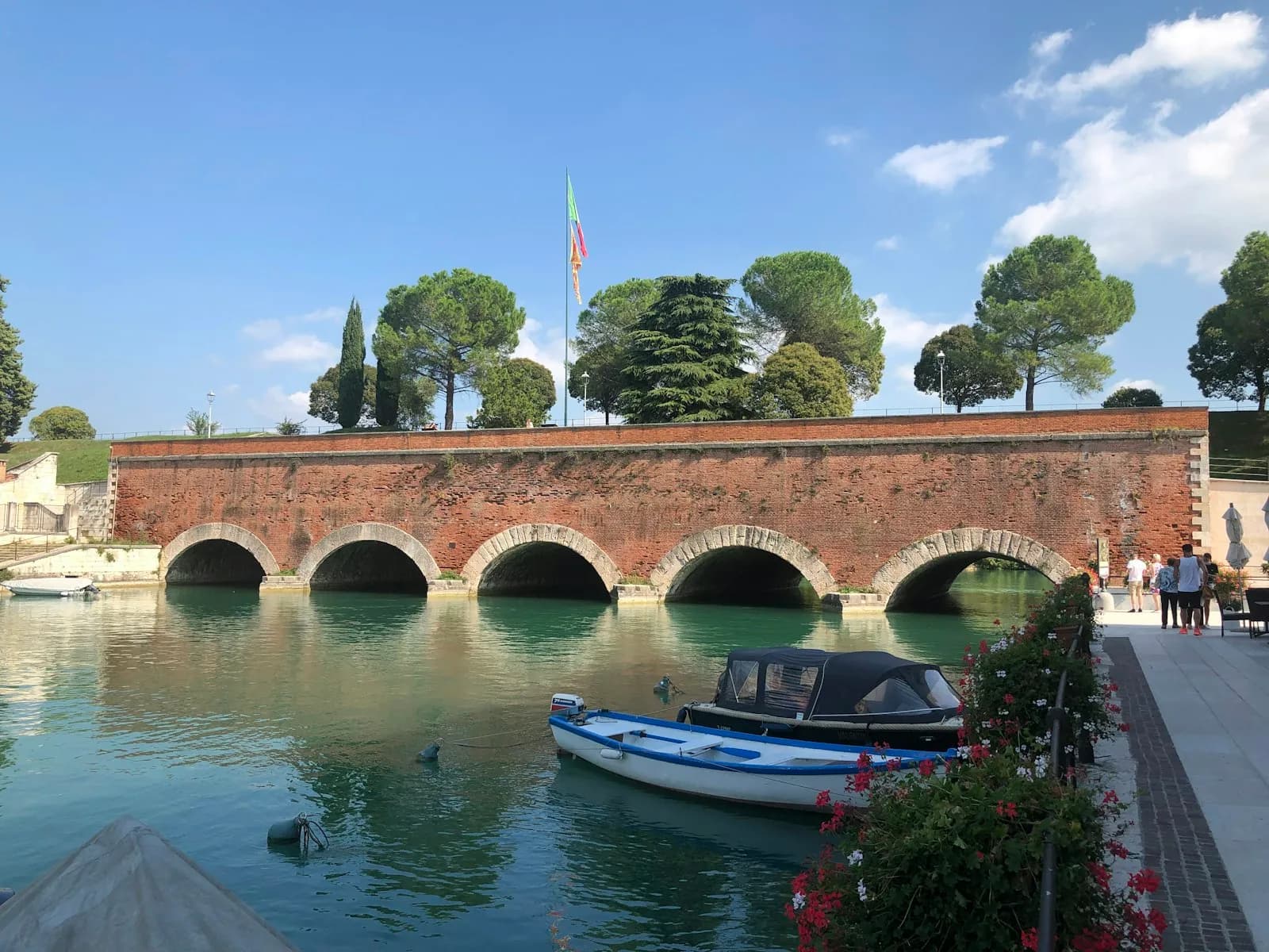 Il ponte veneziano di Peschiera del Garda con una barca ormeggiata sotto gli archi in mattoni