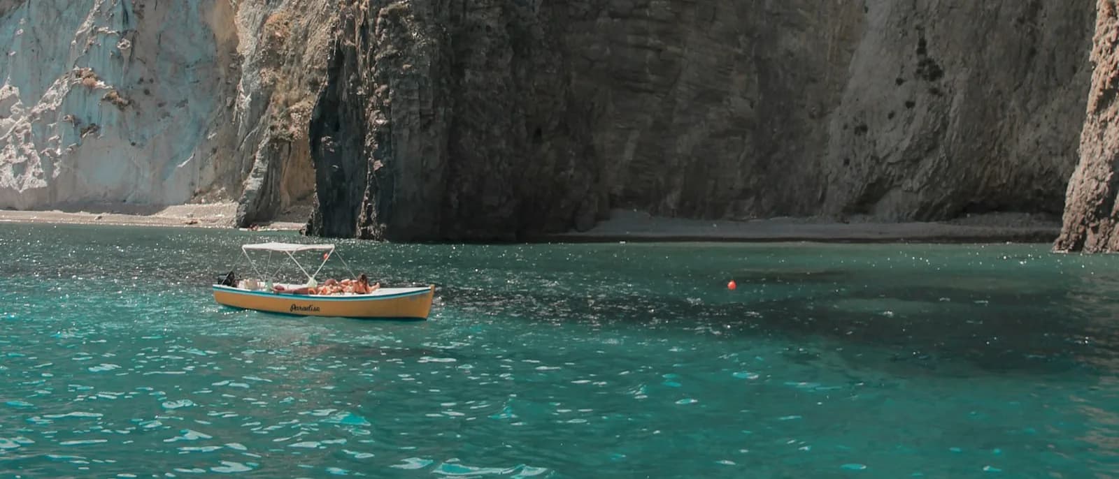 Una barca sul mare lungo la costa rocciosa dell'isola di Ponza