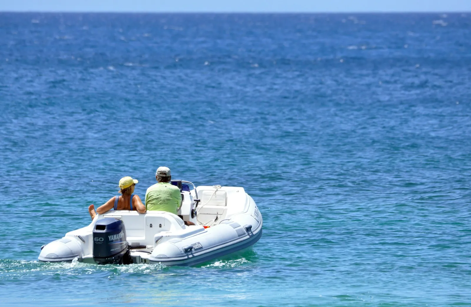 Coppia a bordo di un gommone in navigazione in mare