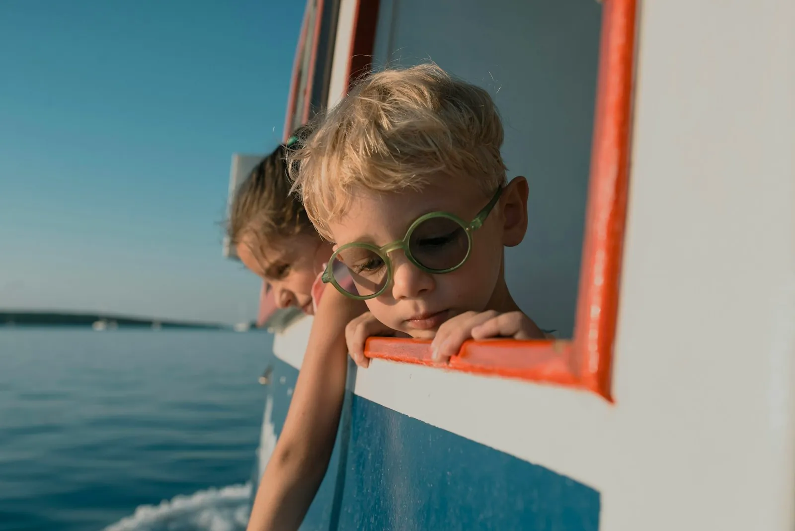 Bambini a bordo di una barca che guardano il mare