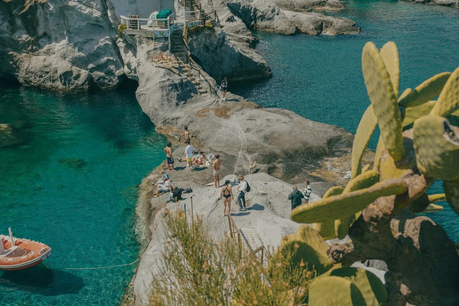 Cala con acqua turchese e barche all'ancora lungo la costa dell'isola di Ponza
