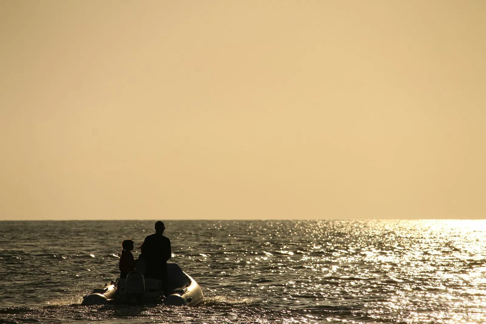 Coppia a bordo di una piccola barca al tramonto sul mare