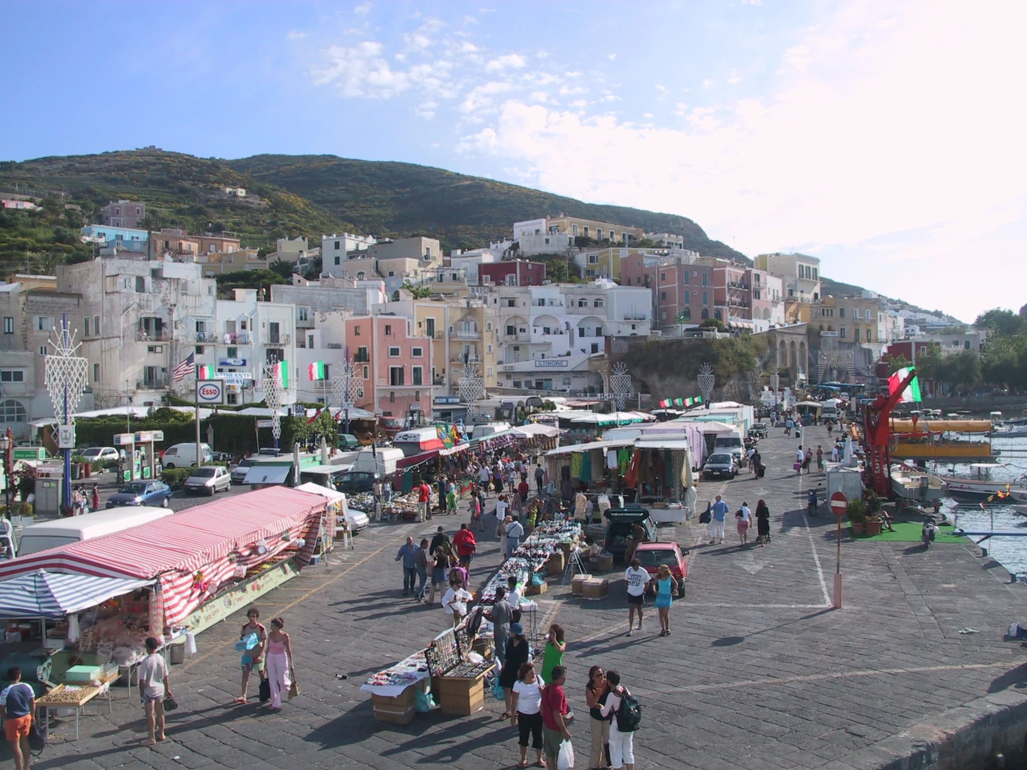 Il porto di Ponza con le case color pastello del borgo affacciate sulla banchina e le barche ormeggiate