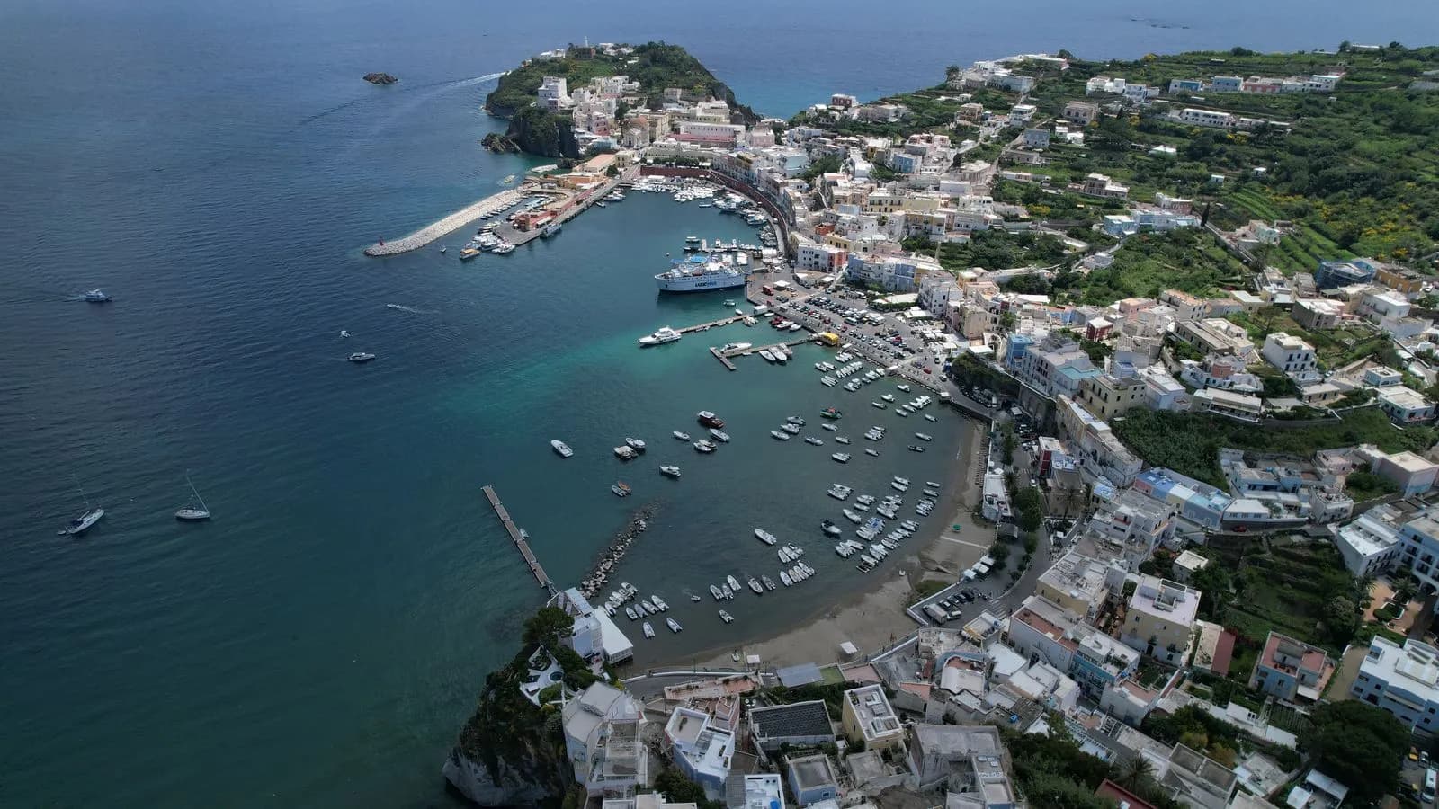 Veduta aerea del porto di Ponza con barche ormeggiate e il paese sulla baia