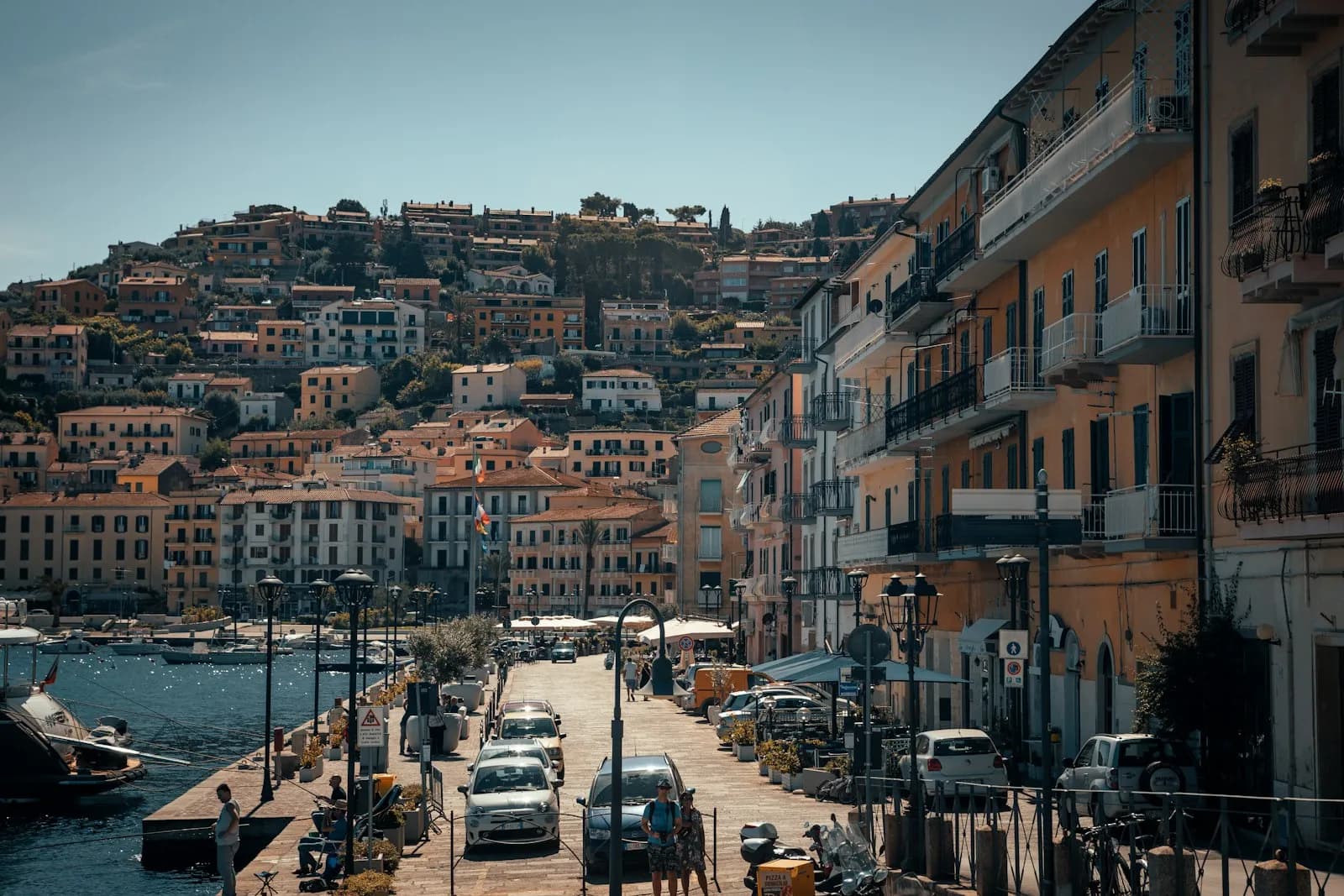 Il lungomare e le case colorate di Porto Santo Stefano, all'Argentario, con le barche ormeggiate nel porto