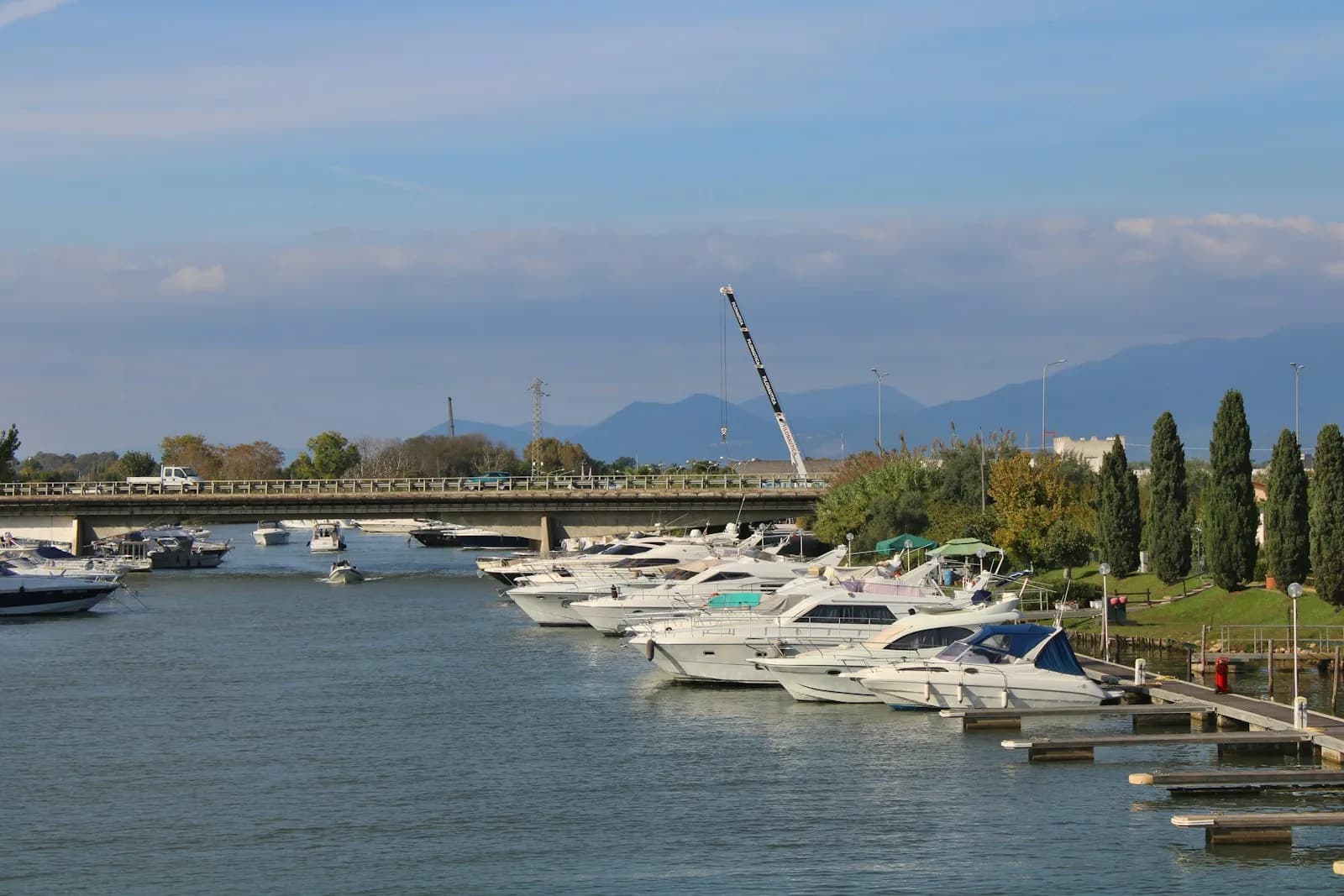 Yacht e barche ormeggiate nel Porto Canale di Terracina, con il ponte e le colline sullo sfondo