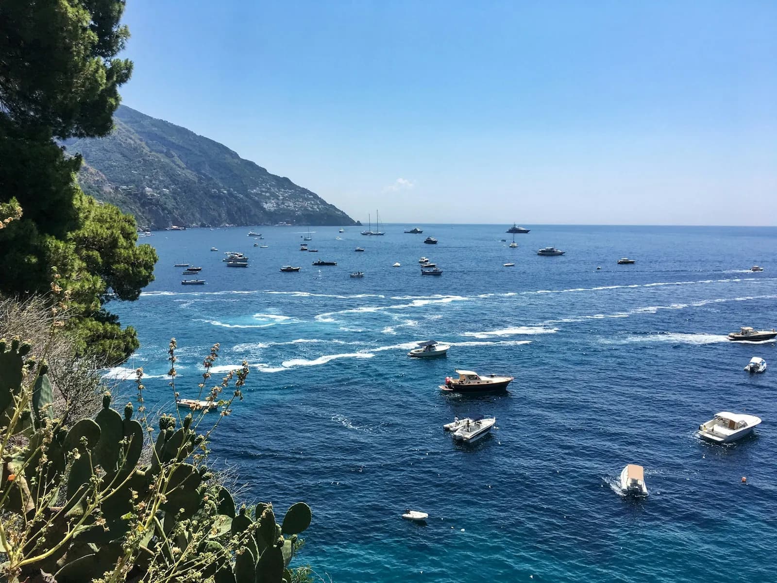 Numerose barche ancorate nella baia turchese davanti a Positano, Costiera Amalfitana