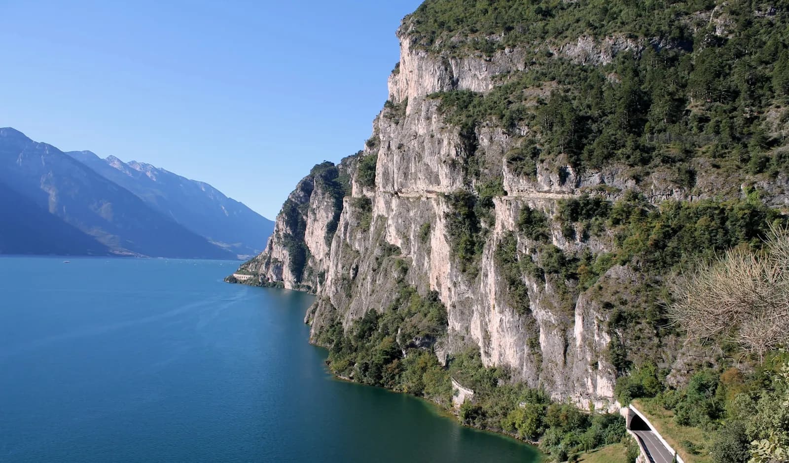 Le pareti a picco dell'alto Garda vicino a Riva del Garda, con la strada scavata nella roccia lungo il lago