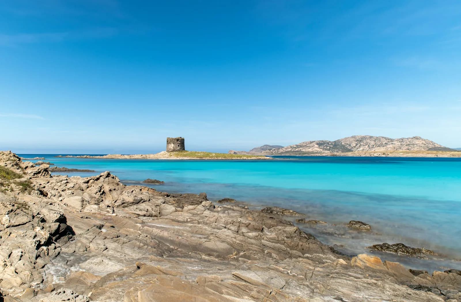 La spiaggia della Pelosa a Stintino con la torre aragonese e l'acqua turchese bassa