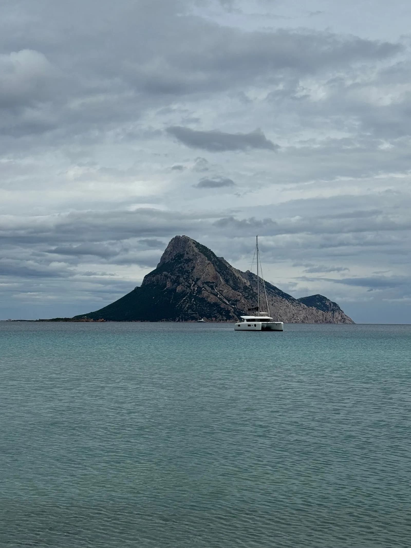 Barca a vela naviga davanti all'Isola di Tavolara, Sardegna