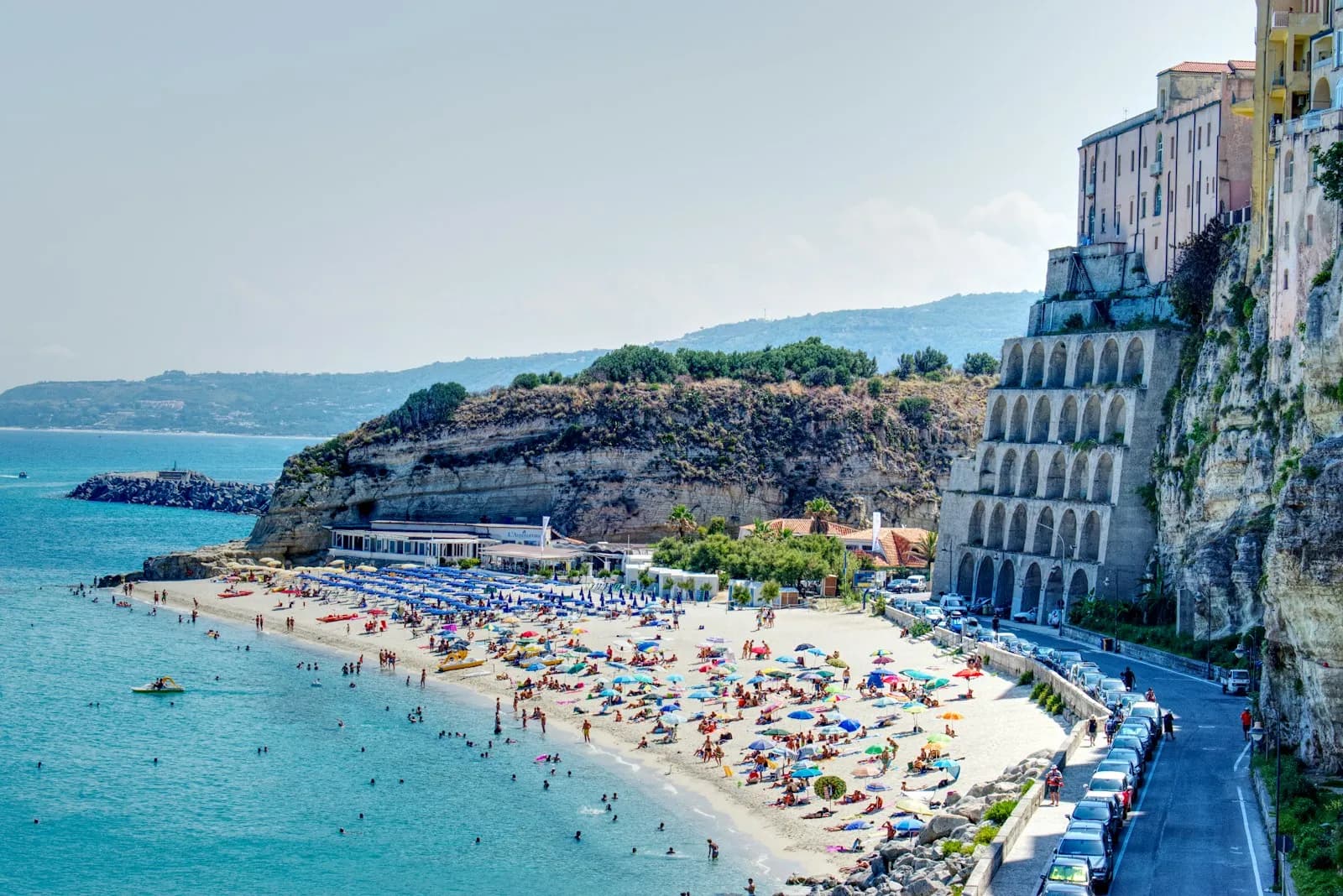 Una cala turchese della costa di Tropea con alcune barche all'ancora