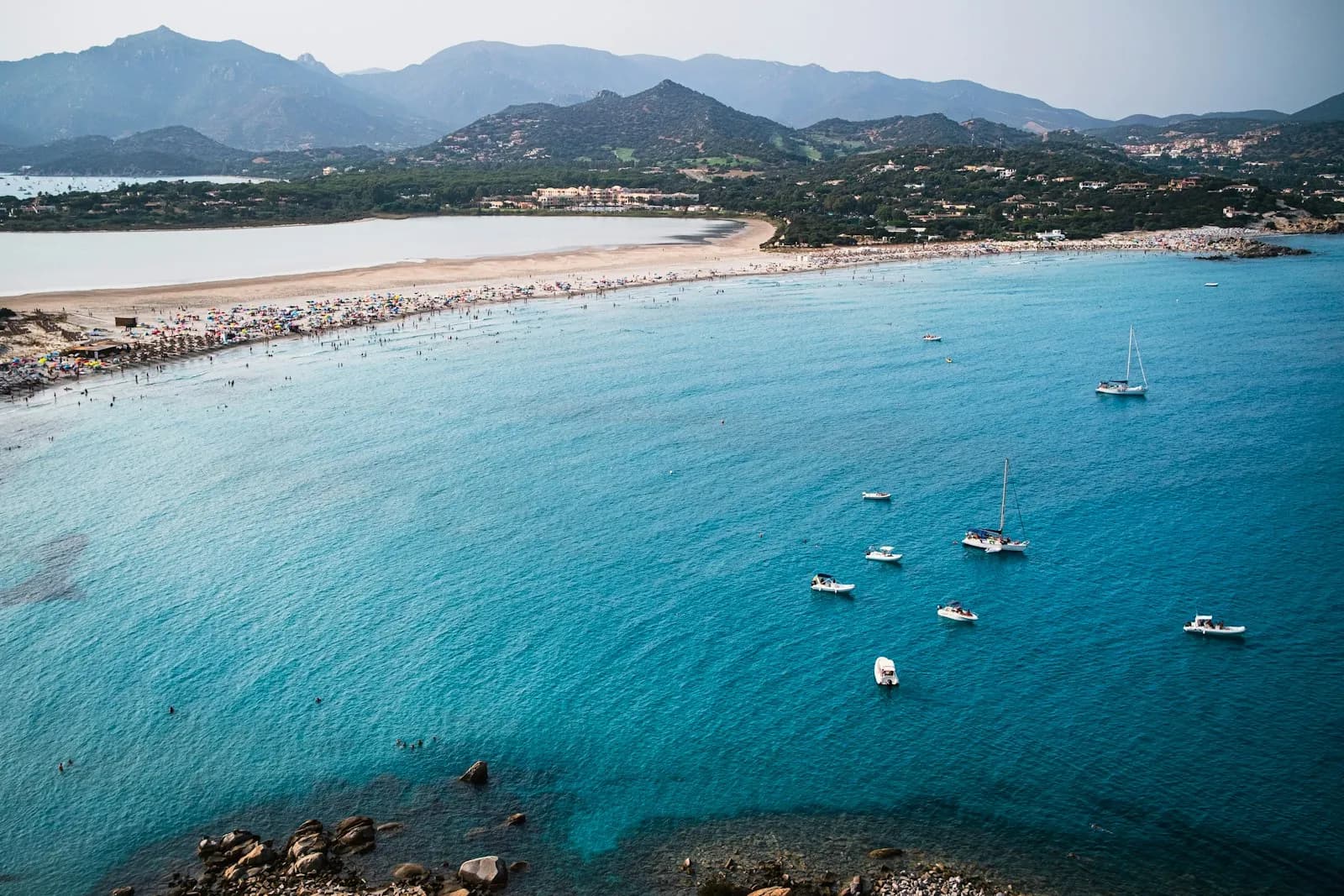 Barche ormeggiate sull'acqua turchese di una spiaggia di Villasimius, in Sardegna