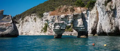 Le falesie calcaree e i faraglioni della Baia delle Zagare sul Gargano visti dal mare