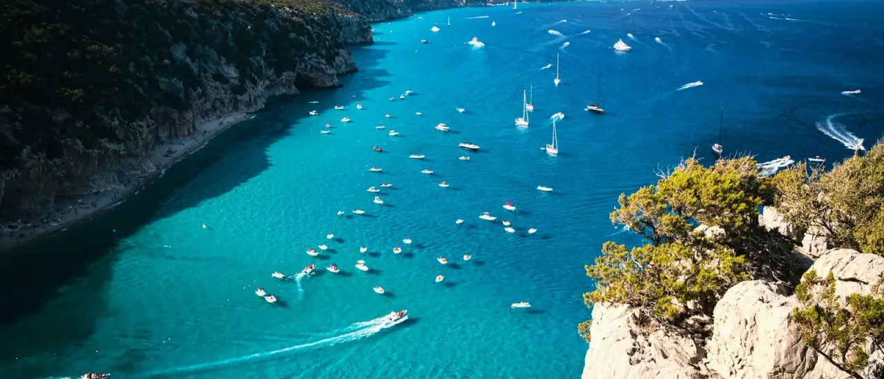 Barche ormeggiate nelle acque turchesi di Cala Luna, nel Golfo di Orosei, raggiungibile in barca da Cala Gonone