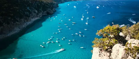 Barche ormeggiate nelle acque turchesi di Cala Luna, nel Golfo di Orosei, raggiungibile in barca da Cala Gonone