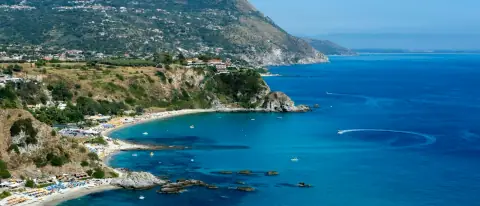 Una baia della Costa degli Dei vista dal mare, con una barca all'ancora