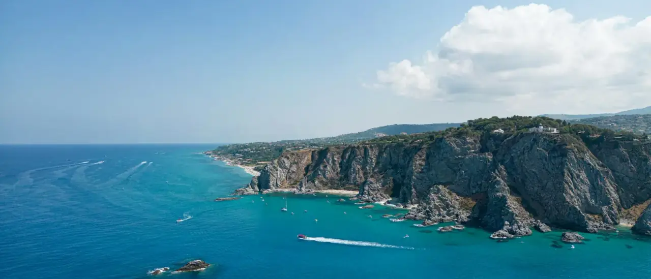 Una cala rocciosa dal mare turchese sulla Costa degli Dei, in Calabria