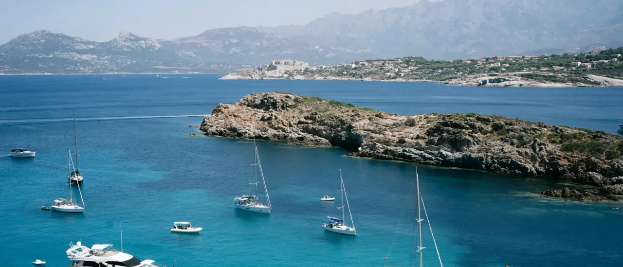 Barche a vela e yacht alla fonda in una baia del Mediterraneo in piena estate