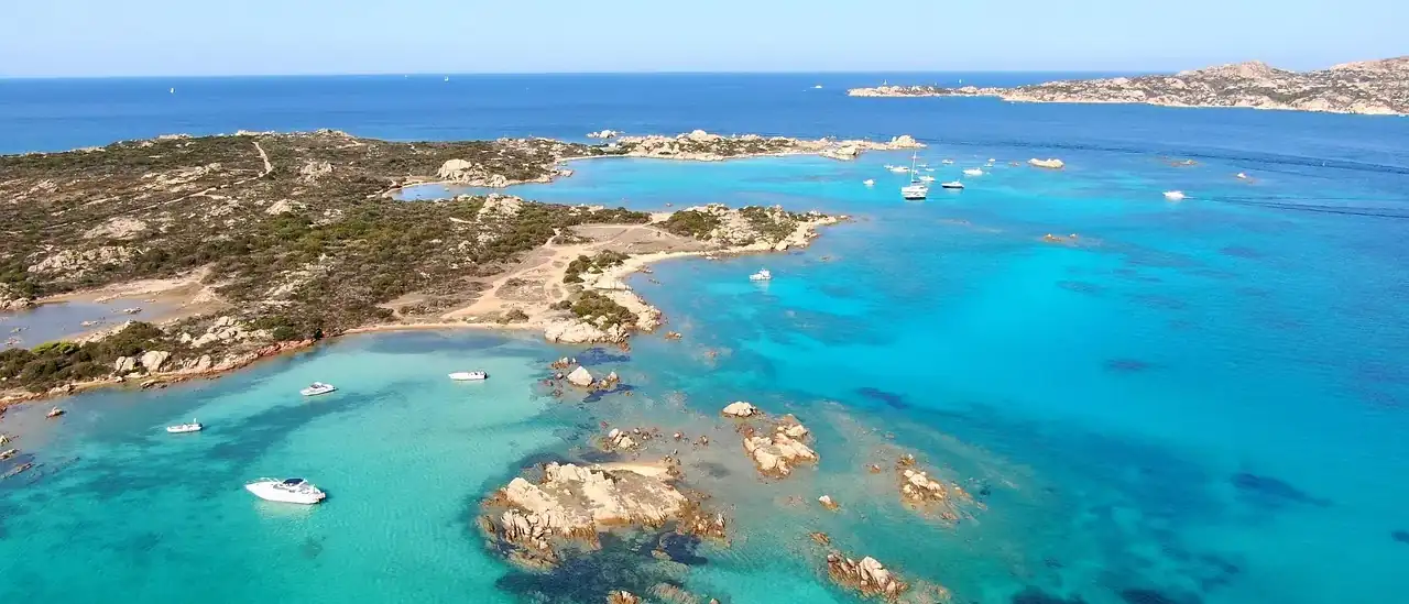 Vista aerea dell'arcipelago di La Maddalena con acque turchesi, isolotti di granito e barche in navigazione