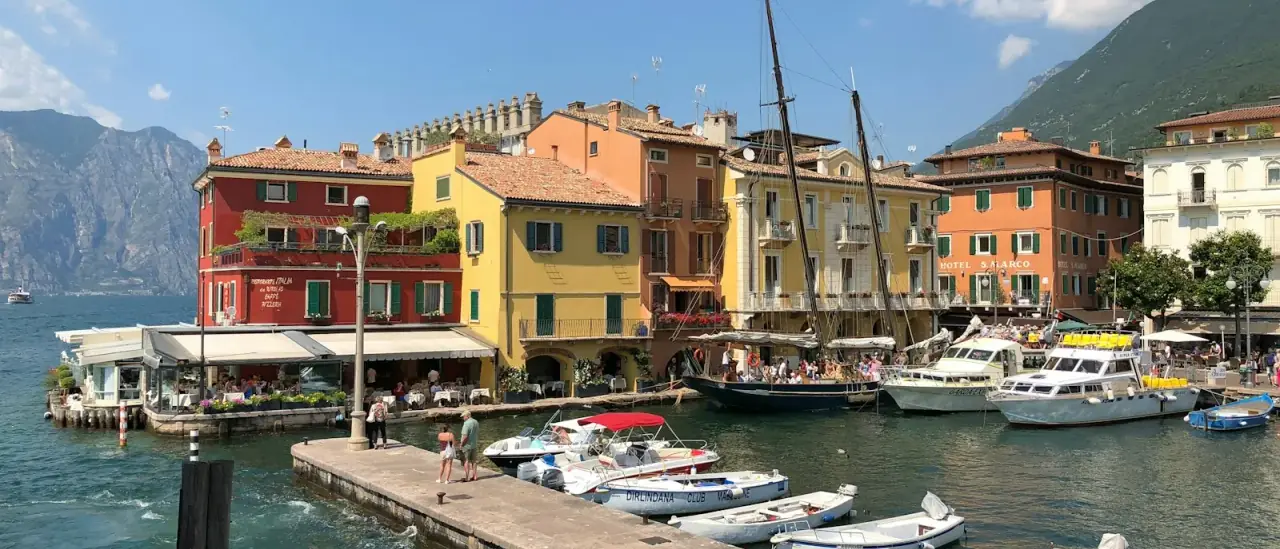 Il porticciolo di Malcesine con barche ormeggiate davanti alle case colorate del centro