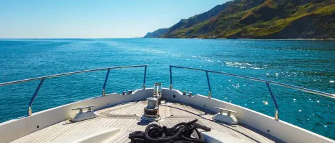 Yacht di lusso con equipaggio ormeggiato in una baia del Mediterraneo