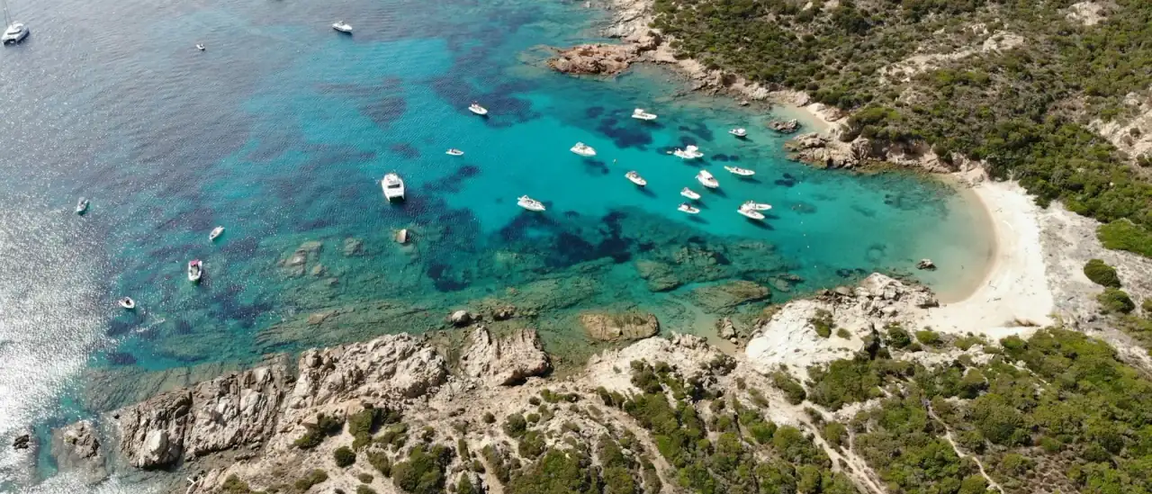 Veduta aerea di barche all'ancora nelle acque turchesi della costa della Gallura, di fronte all'arcipelago di La Maddalena
