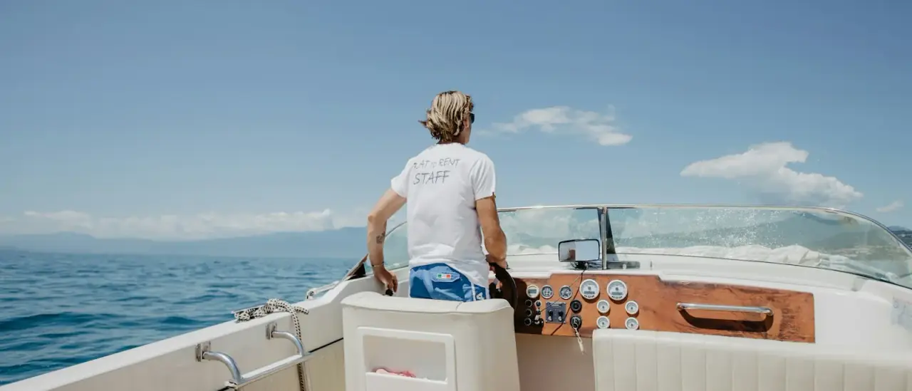 Persona al timone di una barca a motore durante la navigazione
