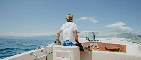 Persona al timone di una barca a motore durante la navigazione