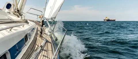Barca a vela in navigazione sul mare aperto con spruzzi d'acqua