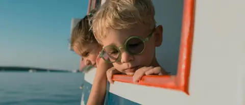 Bambini a bordo di una barca che guardano il mare
