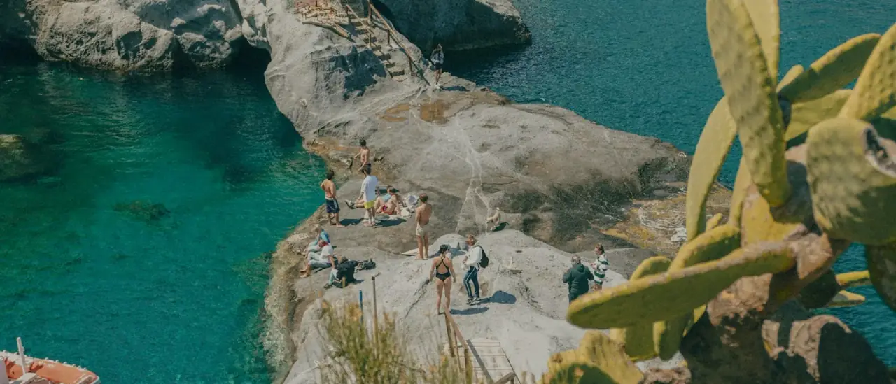 Cala con acqua turchese e barche all'ancora lungo la costa dell'isola di Ponza