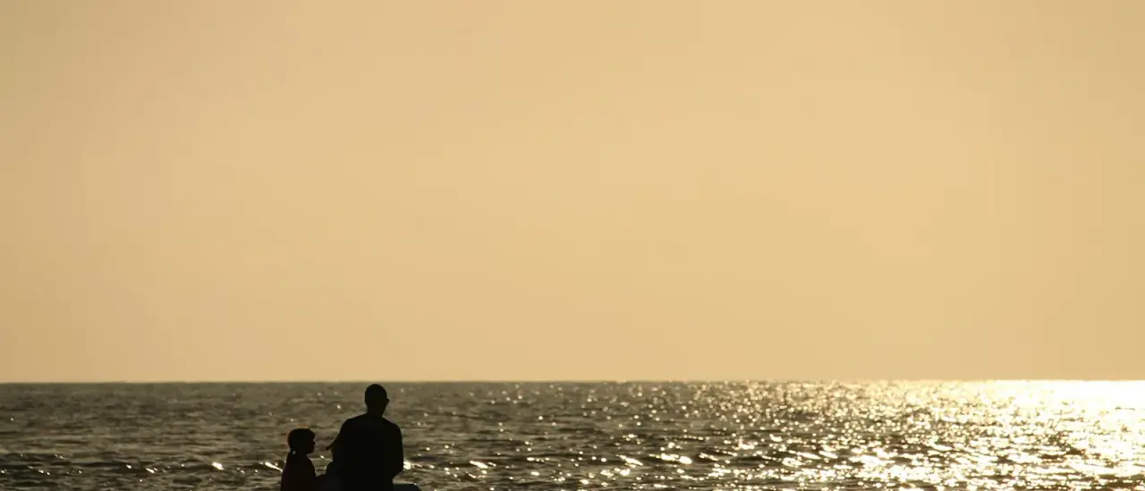 Coppia a bordo di una piccola barca al tramonto sul mare