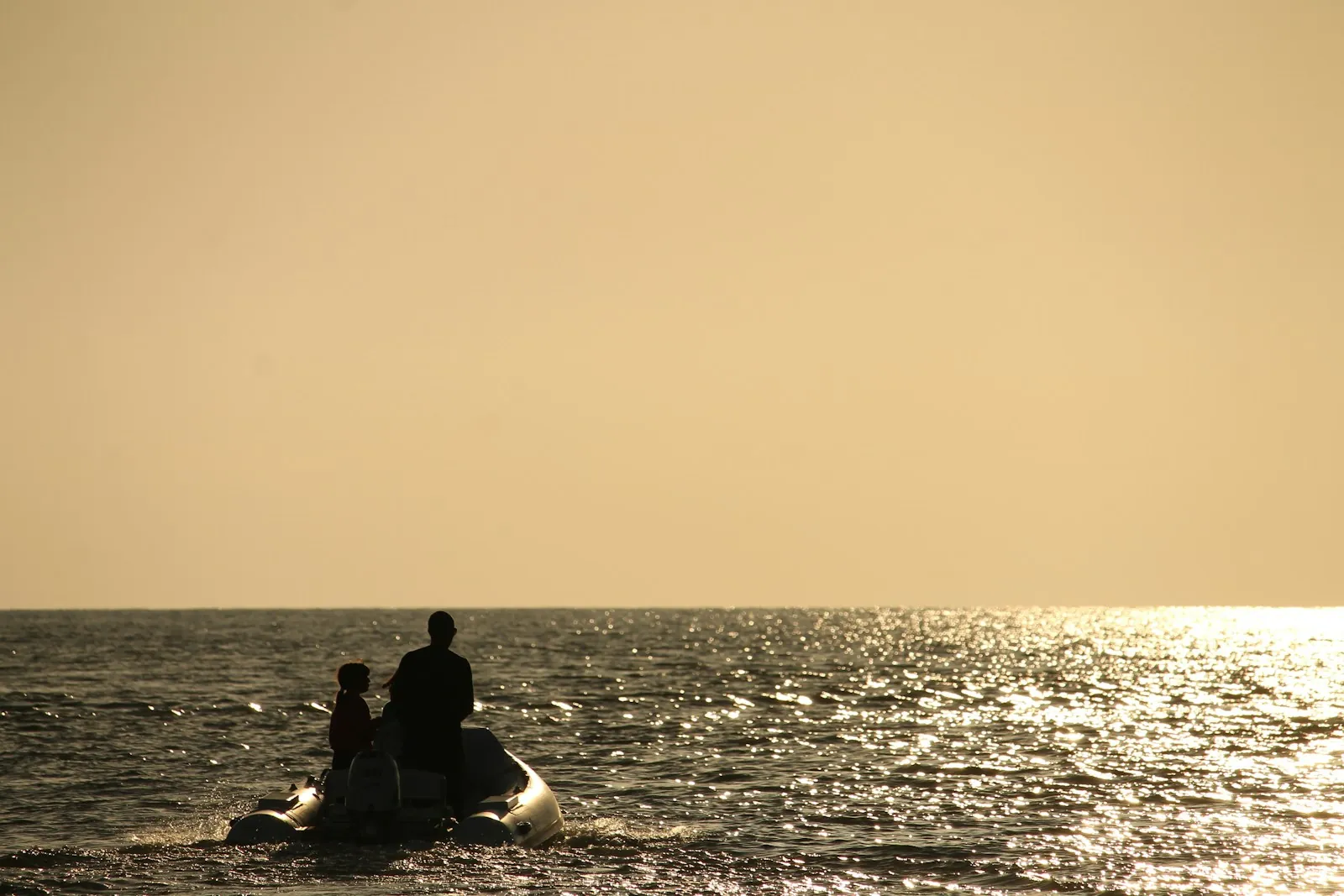 Coppia a bordo di una piccola barca al tramonto sul mare
