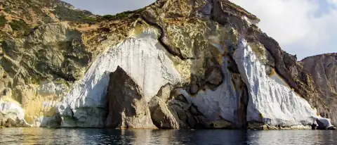 Alta falesia bianca di tufo a picco sul mare a Ponza con grotta marina