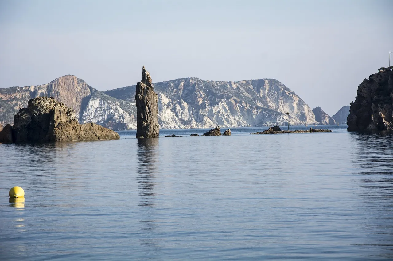 Falesie e faraglioni di tufo bianco dell'isola di Ponza a picco sul mare verde smeraldo